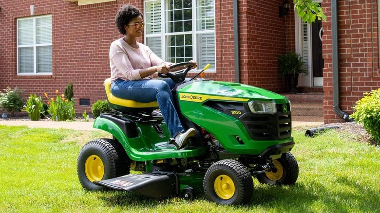 Woman riding John Deere riding lawn mower