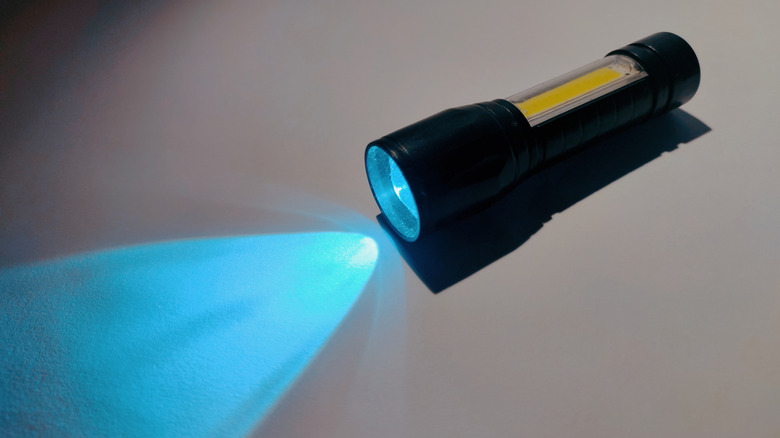 A blue light flashlight shining on white surface