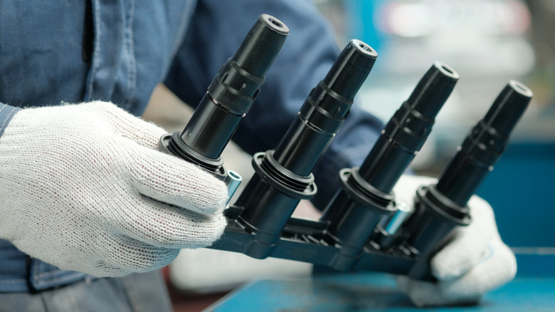 a cassette of ignition coils in a mechanic's hands