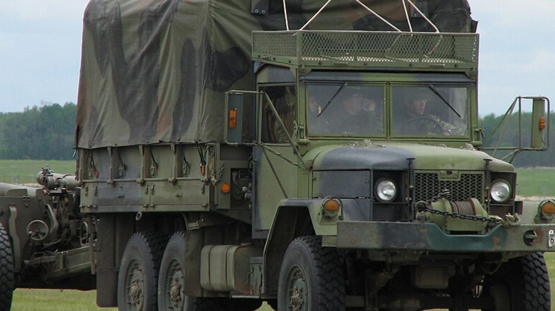Military officials driving M35 truck