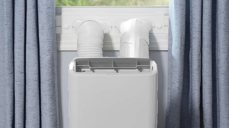 GE 8,000 BTU Class Smart Portable Air Conditioner with optional two hoses installed at a window