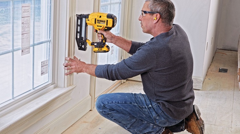 Person using a DeWalt nail gun