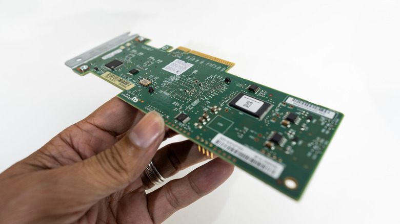 A RAID controller card is held in a hand