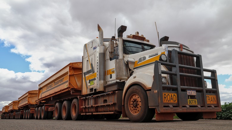 A road train with four trailers parked on a road