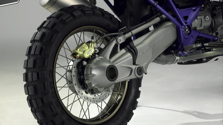 Spoked motorcycle rear wheel connected to a gearbox by a shaft drive.
