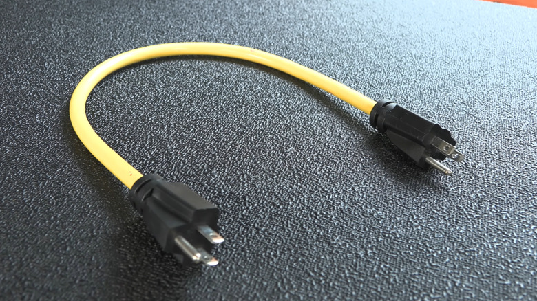 A male to male extension power cord on black surface