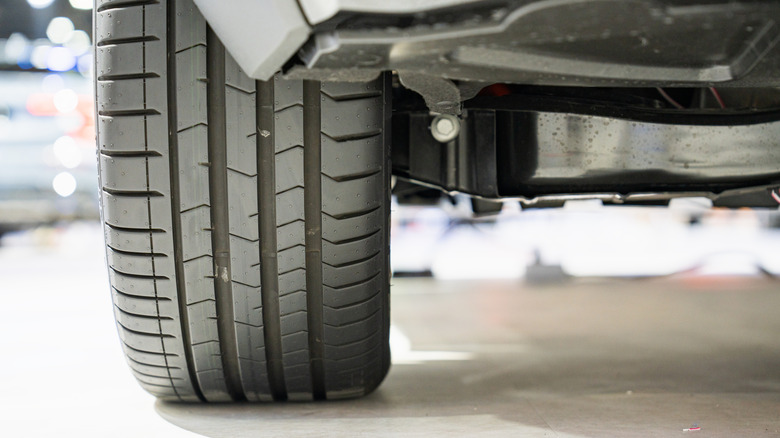 A close-up of a rear tire on an unidentified car, blurry background