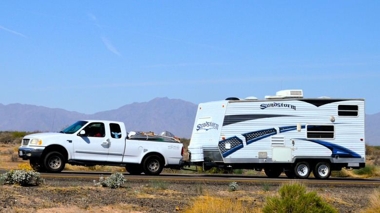 A travel trailer's tongue weight sags the back of a pickup truck.