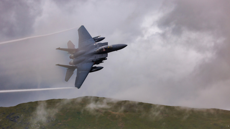 F-15 fighter jets banking over a mountain range