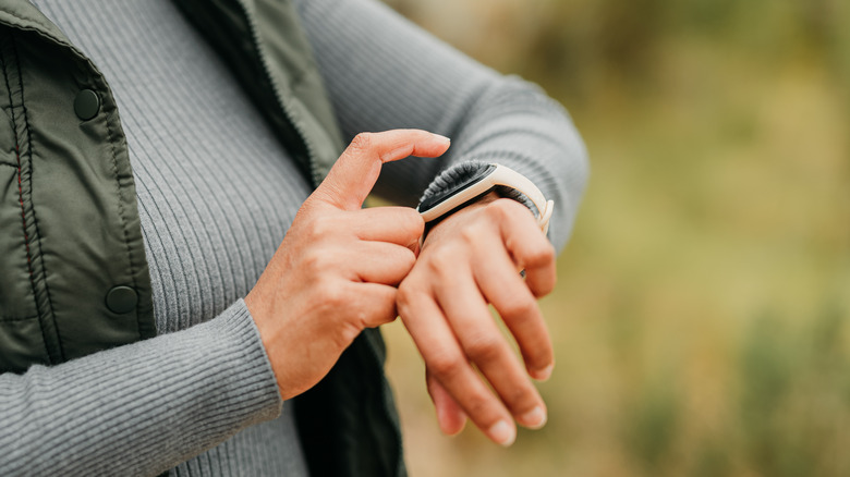 person tapping at smart watch