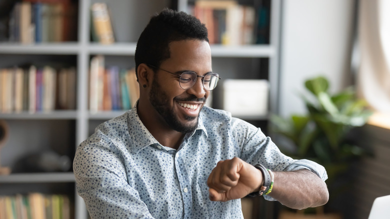 person smiling at smart watch