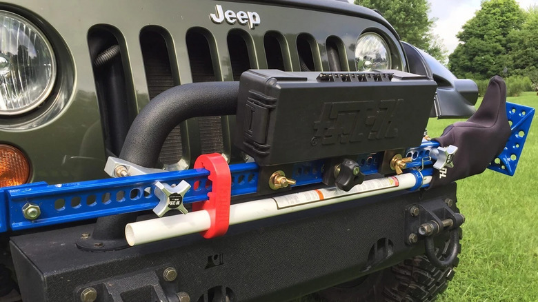 The Hi-Lift Cast/Steel Jack mounted on a jeep