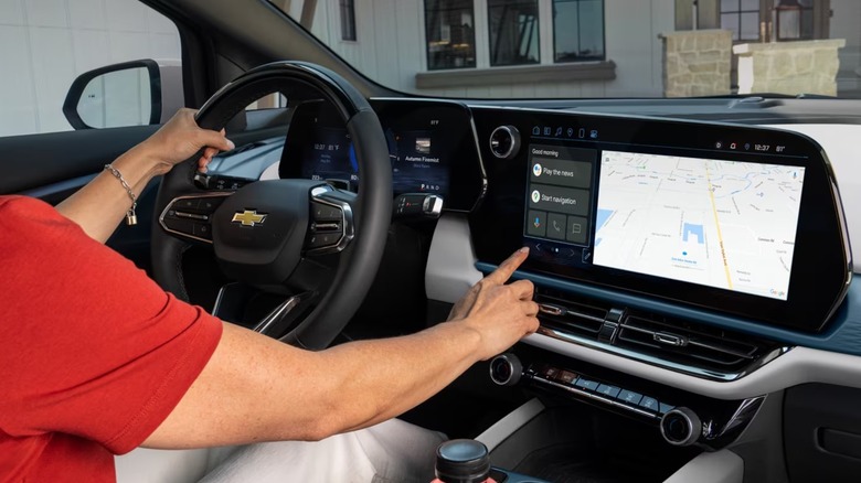 a woman operates a google built in touch screen on a chevy