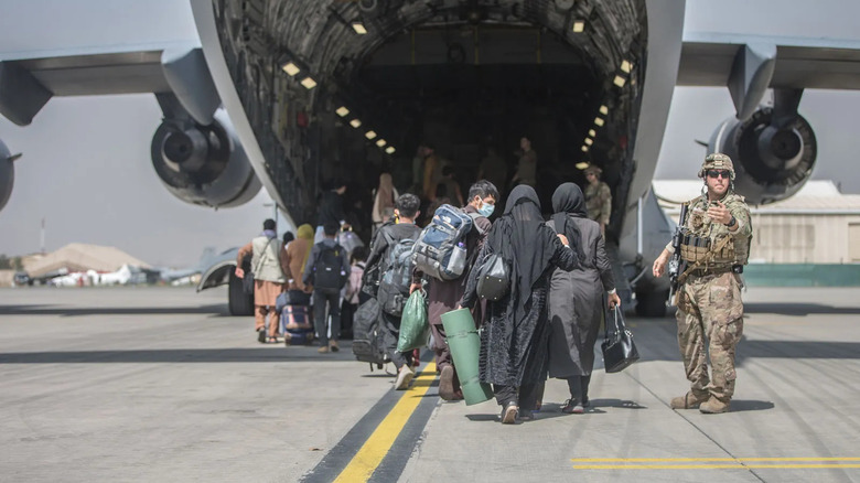 Families board U.S. Air Force aircraft during the evacuation of Kabul