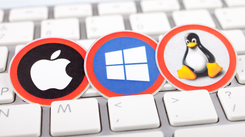 Apple, Windows and Linux logos on a white keyboard