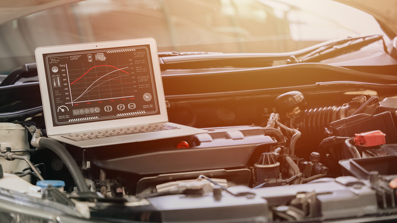 A laptop placed on top of an engine for ECU tuning