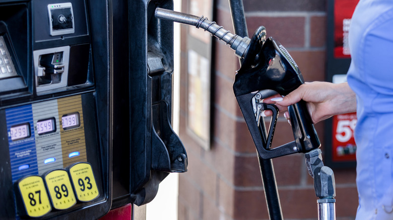 person holding gas pump handle