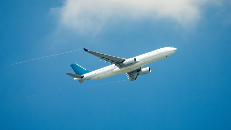 Passenger jet airplane over clouds