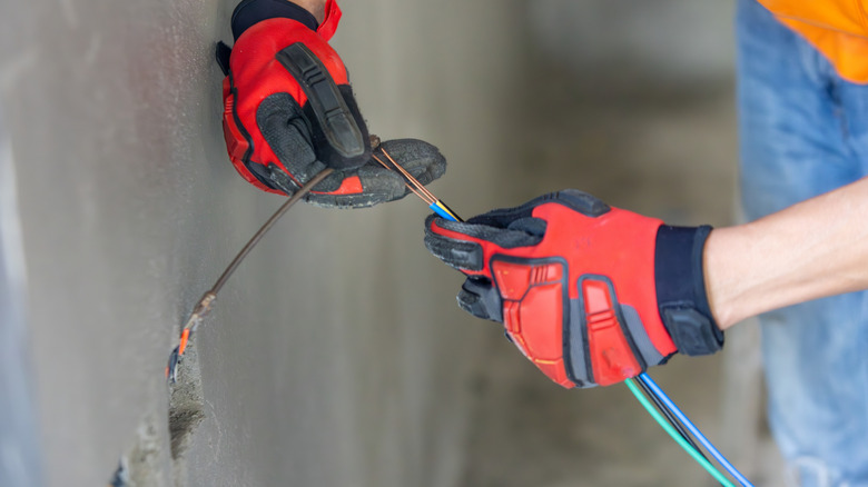Electrician using fish tape to get the wires on the other side of wall
