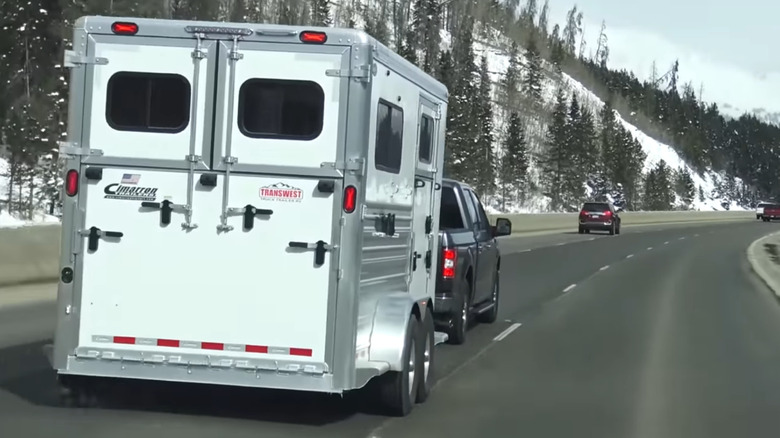 rear profile view shot of a Ford F-150 truck towing a trailer