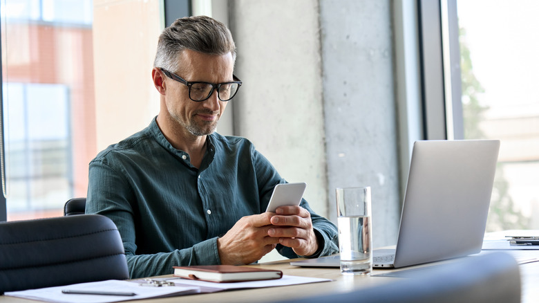person using phone at desk