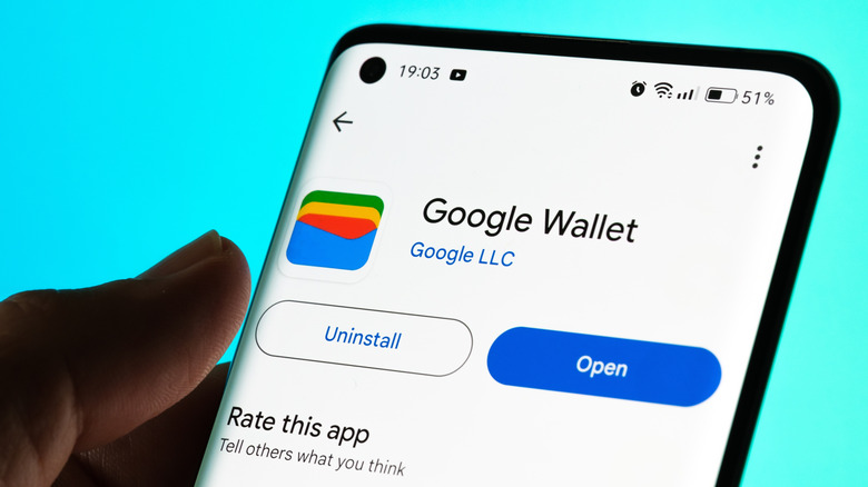 Person holding phone with Google Wallet on scren