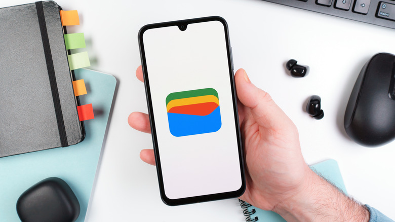 Person holding phone with Google Wallet on scren