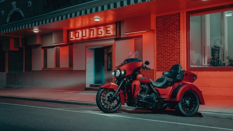 Harley-Davidson Tri Glide Ultra parked outside a lounge at night.