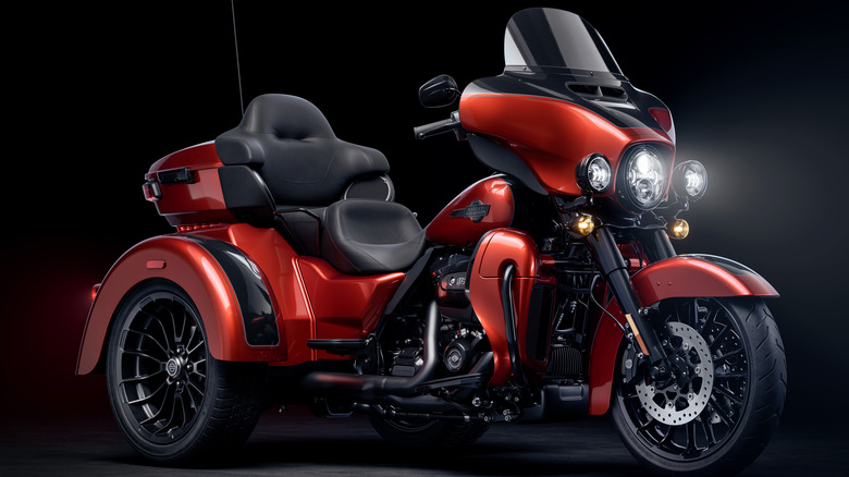 Red Harley-Davidson Tri Glide Ultra with black background.