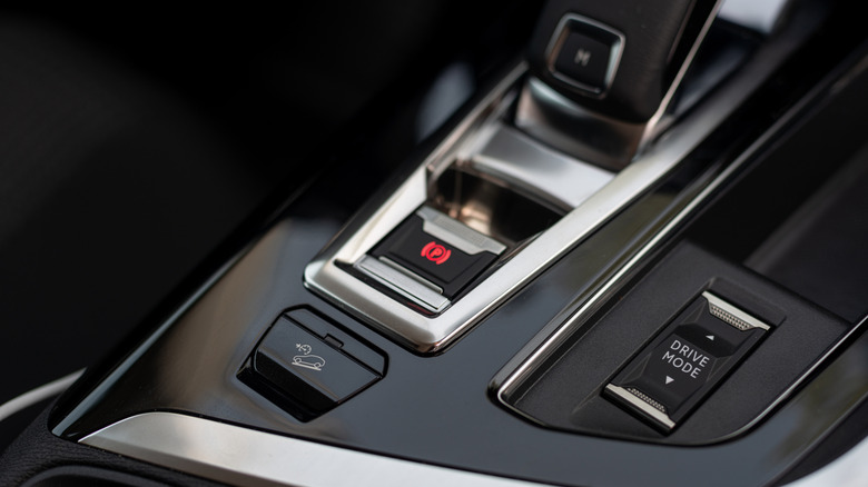 A close up photo of a modern SUVs center console showing a Hill Descent Control button.