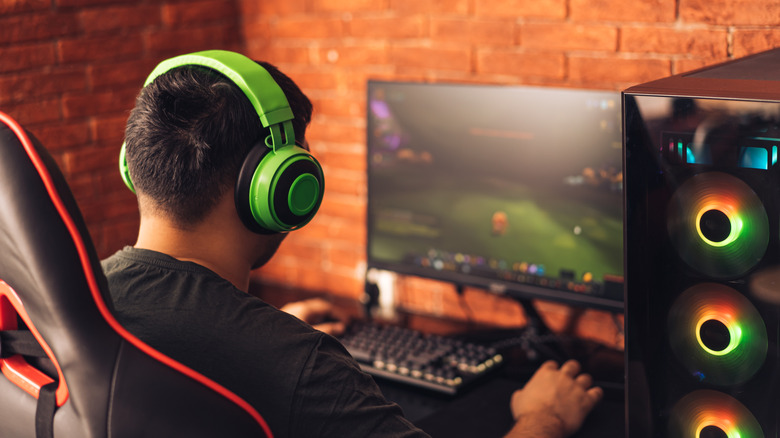 A person playing a game on a gaming PC setup