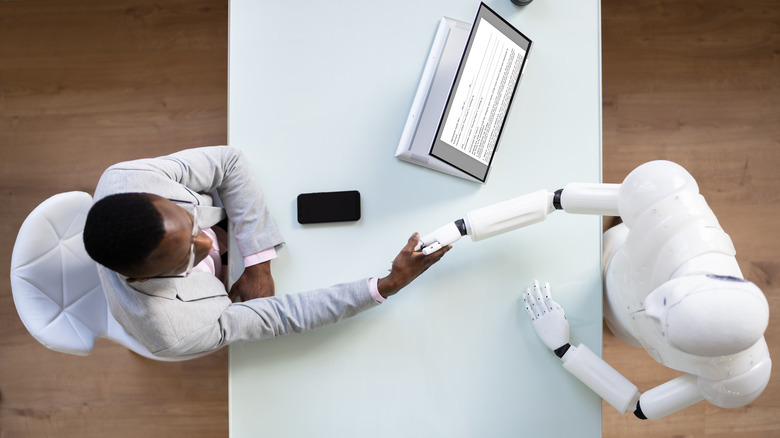 Person shaking hands with a robot