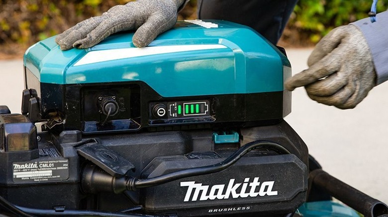 Makita backpack power supply attached to mower