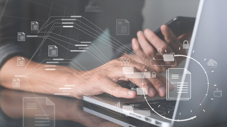 man working on a laptop with digital paper format graphic