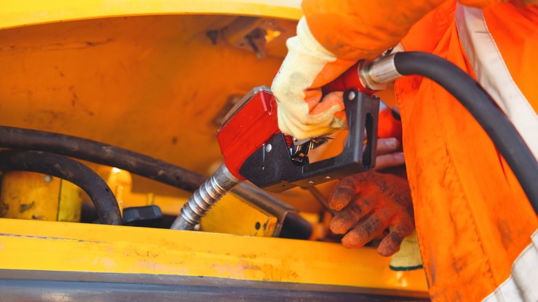 Person refuels heavy machinery at a construction site