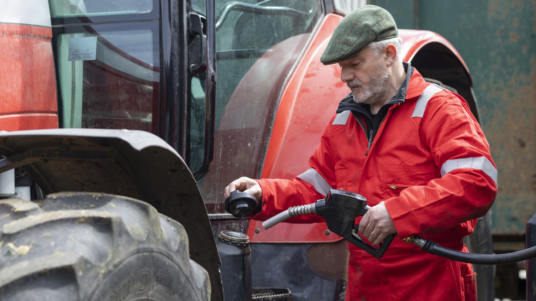 farmer refueling agricultural vehicle