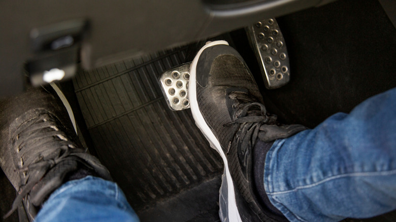 Close up of person's feet pushing clutch pedal in