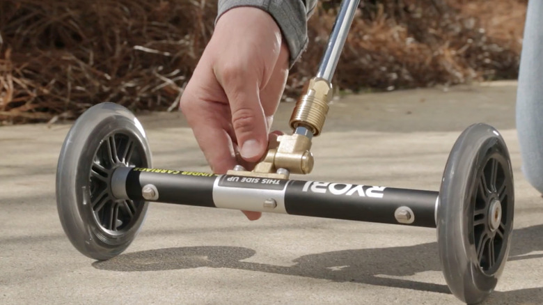 person touching Ryobi water broom