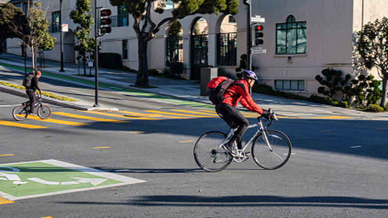 Two bicyclists crossing a wide intersection
