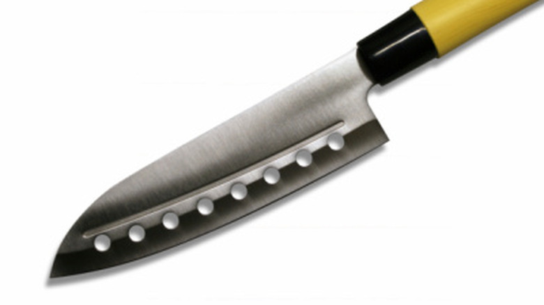 A chef's knife with holes in the blade