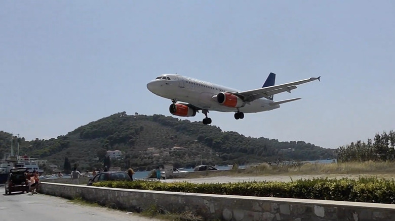 A plane lands near a hilly area