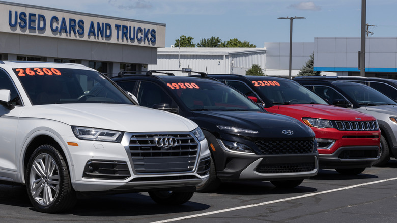 Used cars on display at a dealership parking lot