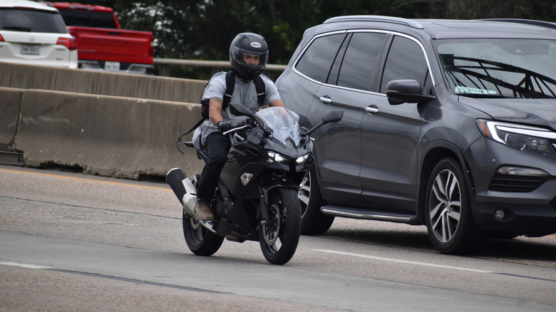 Motorcycle on the highway next to vehicle