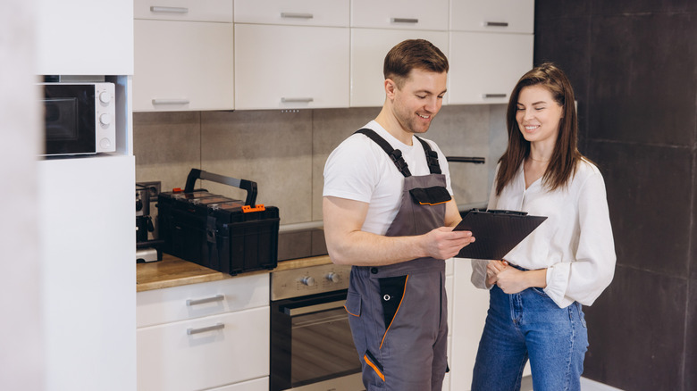 A repairman showing the bill to a homeowner