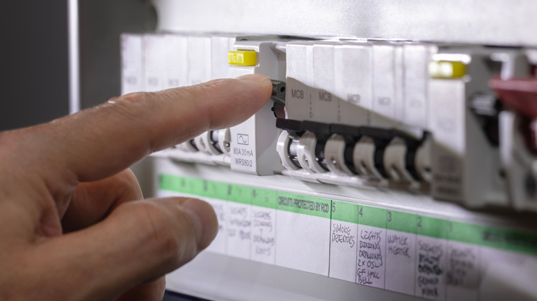 A hand operating a circuit breaker switch