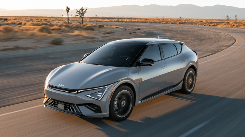 A Kia EV6 driving around the bend of a desert road