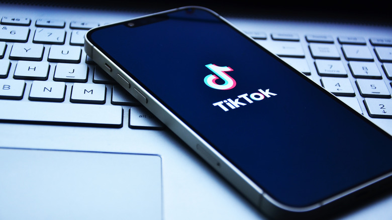 Tiktok logo on smartphone placed on top of computer keyboard