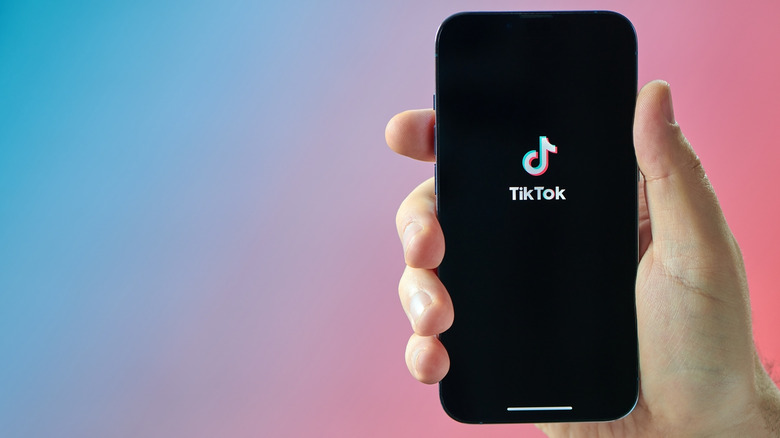 Person holding a smartphone with the TikTok logo