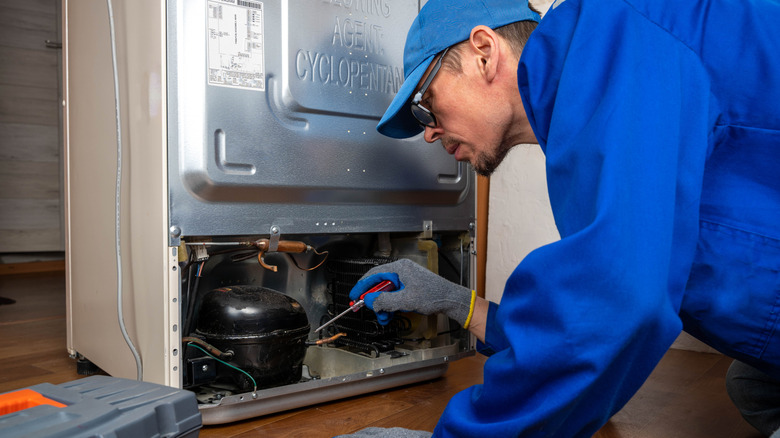 A technician fixing a refrigerator