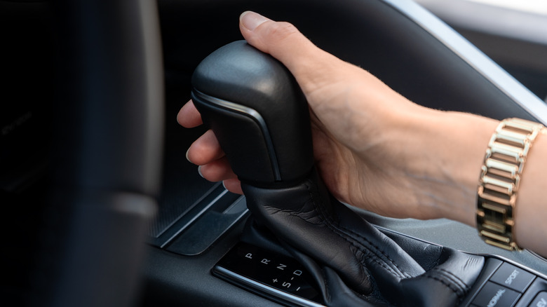 Close-up of hand resting on automatic transmission shift knob